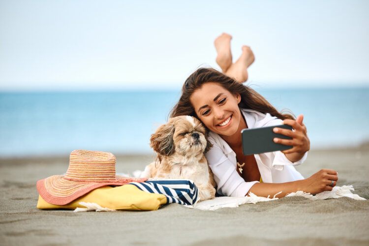 Imagen descriptiva mujer disfrutando playa con su perro Peluqueria canina San Pedro de lla Paz